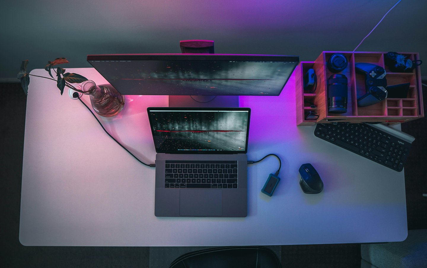 Laptop and accessories arranged on a white desk.